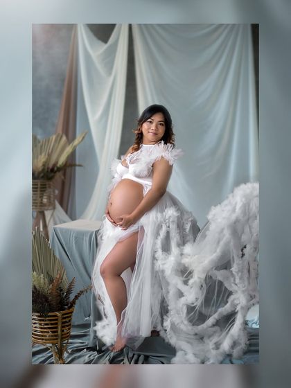 A full-length portrait showcasing a stunning, cloud-like tulle gown that makes the expecting mother look like she's floating on air.
