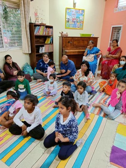A group of children and adults listen intently, a typical scene at our popular Friday story sessions.