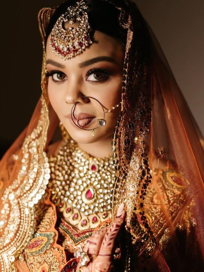 A classic bridal close-up, focusing on the bride's stunning makeup and heavy polki necklace.