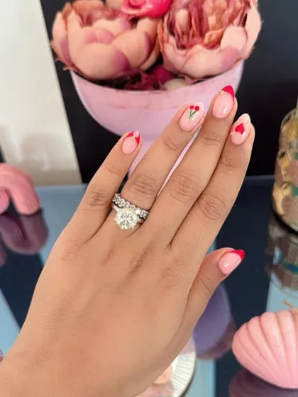Nail inspiration showing a romantic set with red French tips, tiny hearts, and a tulip accent nail.