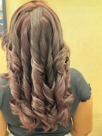 The back view of a stunning, deep red hair color styled into glamorous curls. This look is all about drama and elegance, with a rich tone that catches the light beautifully.