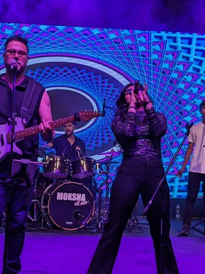 The band under vibrant blue lights at The Galleria Mall. This image showcases our stage presence and the visually stunning production we bring to our shows.