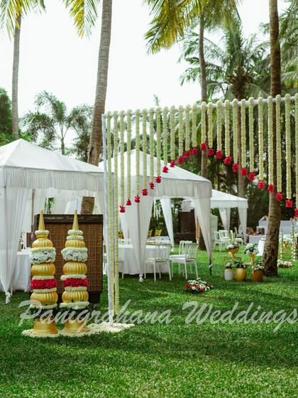 A clean and elegant Mehendi setup in Goa, with white cabanas and traditional floral arrangements creating a serene and sophisticated beachside vibe.