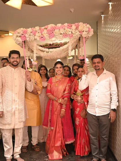 The bride's entrance under a floral canopy held by her brothers, a beautiful tradition captured perfectly.