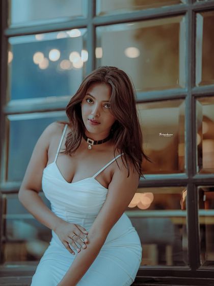 This portrait captures a confident and direct gaze. The cool tones and the window background give it a modern, urban feel.