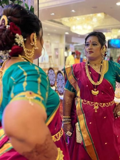 A candid mirror shot showing the complete traditional look. The kamarbandh (waist belt) and layered necklaces create an authentic and regal silhouette.