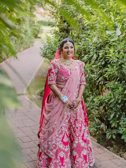 This bride in her red lehenga looks radiant and happy. The makeup is designed to be timeless, ensuring her wedding photos are cherished for years to come.
