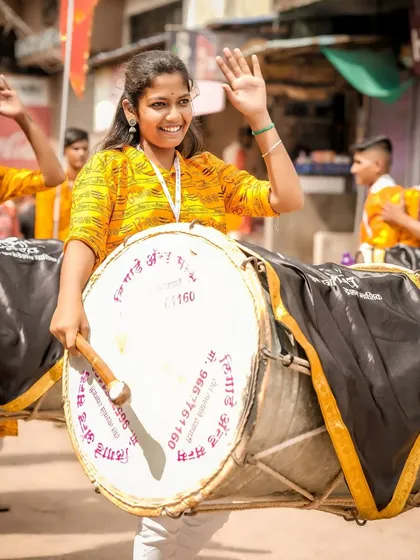 The color version of the waving dhol player, full of joy.