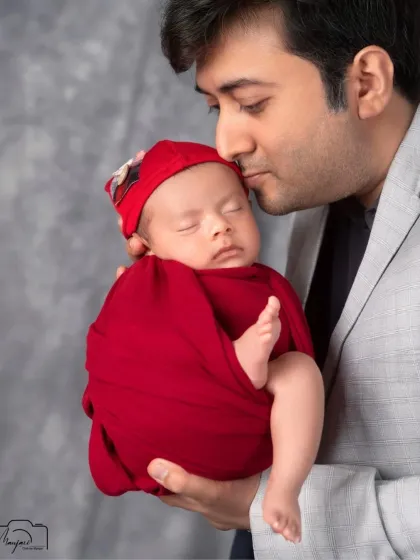 A father's gentle kiss. This portrait of a dad and his newborn is full of tenderness and love.