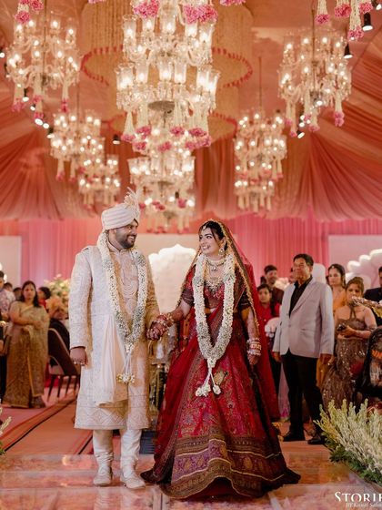 The couple walking down the aisle under a ceiling of magnificent chandeliers, a truly grand moment.