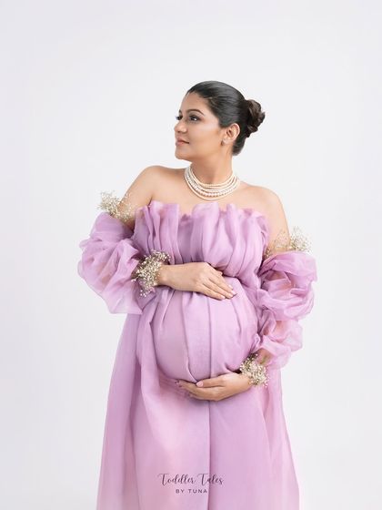 A portrait of regal elegance. The off-shoulder lavender gown, pearl necklace, and delicate floral details on the sleeves create a look fit for a queen.