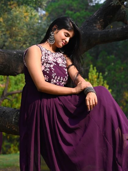 A full-body shot showing the model seated on a tree branch, creating a unique and memorable composition.