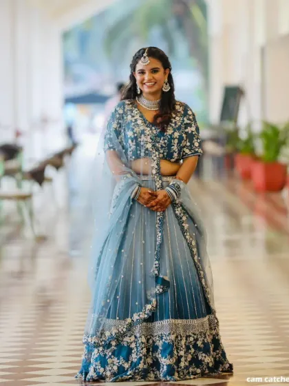 A full-length photo of our client looking absolutely beautiful in the blue ombre lehenga. The fit is perfect and she carries it with so much grace.