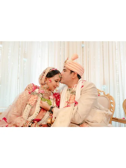 A tender kiss on the forehead. A quiet moment of blessing and love amidst the grandeur of the wedding ceremony.