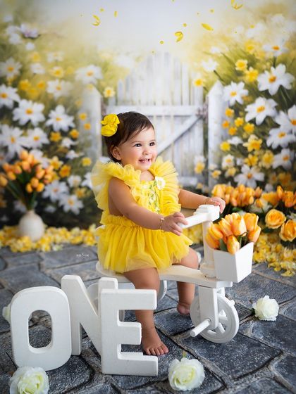 A ray of sunshine in her own yellow flower garden. This cheerful and bright setup with daisies and tulips is perfect for celebrating a happy first birthday.