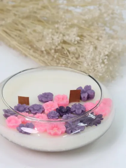 Another beautiful floral creation for Women's Day. This low, wide glass bowl candle is decorated with pink and purple flower wax melts, creating a lovely miniature garden of light.