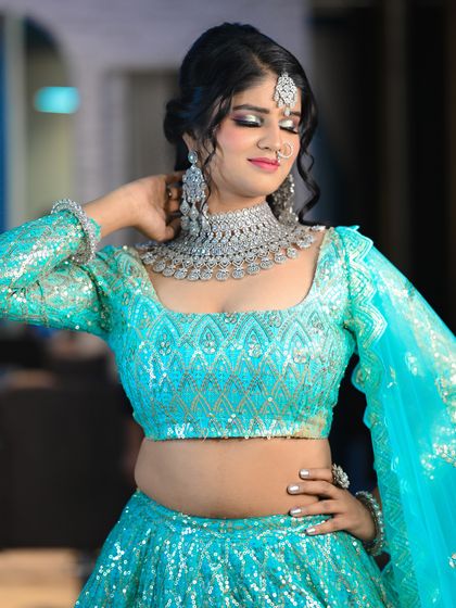 Another beautiful shot of the bride in her shimmering blue lehenga, capturing a moment of quiet grace.