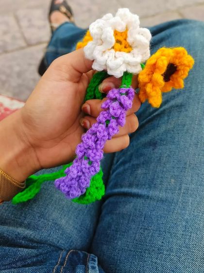 A handful of my crochet flowers, including a daisy, a sunflower, and a sprig of lavender. This is how a custom bouquet starts!