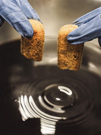Dipping ladyfingers in coffee, the traditional first step for making our classic Tiramisu.
