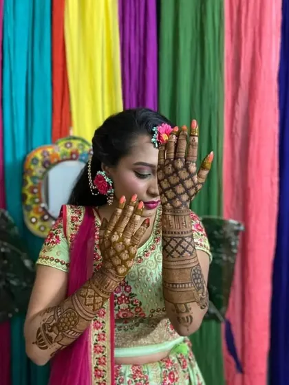 This bride chose a delicate jaali pattern for the back of her hands. The design is paired with floral jewelry, showing how well the mehndi complements bridal accessories.