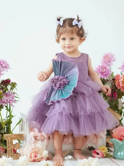 A beautiful portrait for a first birthday. This little girl is dressed in a lovely purple gown, surrounded by flowers for a tea party theme.