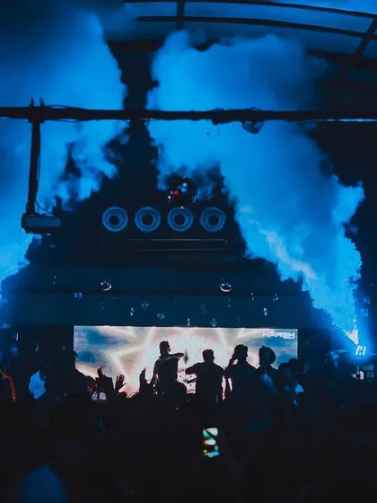 The stage at MOBE 26, lit up by blue CO2 jets and a hyped-up crowd.