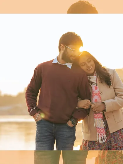 The perfect golden hour glow. The setting sun creates a beautiful flare as the couple shares a warm, cozy moment by the river, showcasing the magical light we love to shoot in.