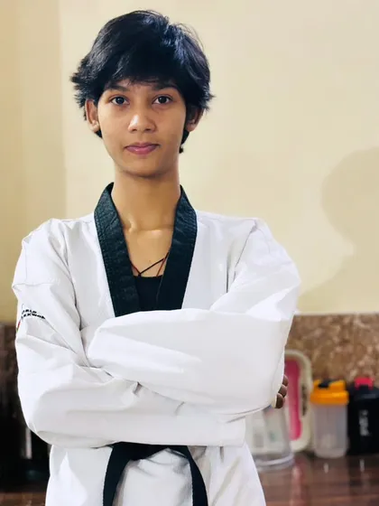 A confident black belt student at our academy. The uniform represents discipline, and her expression represents the quiet confidence that comes with it.