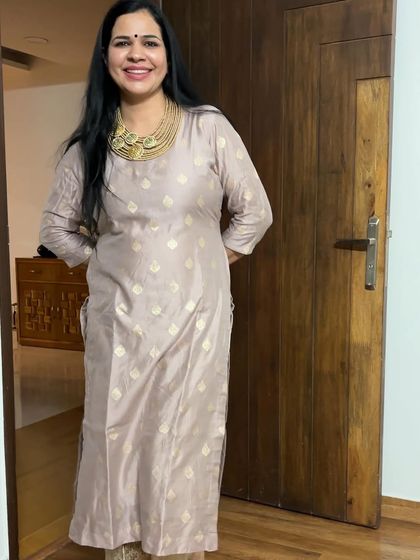 This light pink suit with gold embroidery is a very elegant and understated piece. It's perfect for those who prefer softer colors for festive wear.