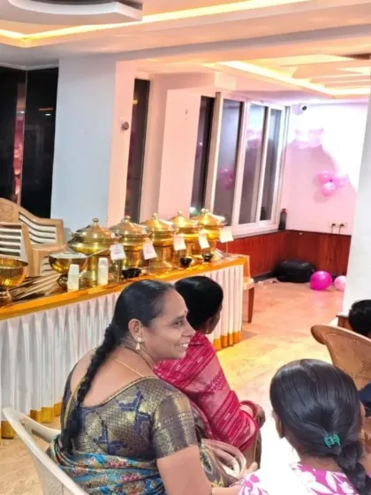 Guests seated and enjoying their time at an indoor family function. Our buffet is conveniently set up in the background, allowing for easy access and a relaxed atmosphere.