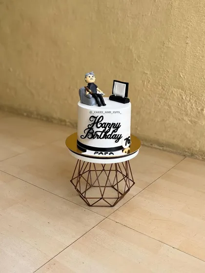 A custom cake for "Papa's" 76th birthday, featuring a fondant figurine of him relaxing in his chair.