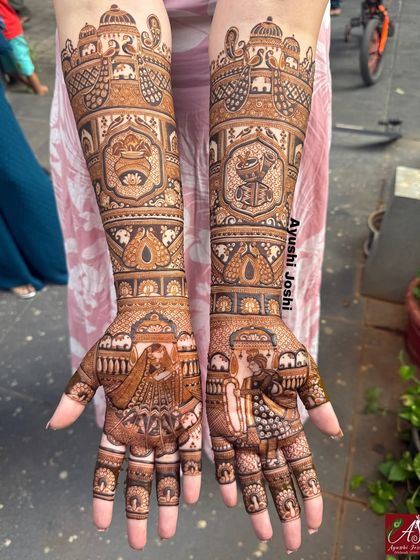 A stunning bridal design capturing the Varmala ceremony. The arms feature royal elephants, peacocks, and symbols of celebration like the dhol, shehnai, and kalash.