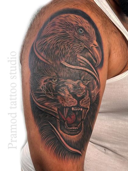 The final result of a major cover-up on the bicep. A faded sun tattoo is now a powerful and realistic fusion of a lion and an eagle, symbolizing both strength and vision.