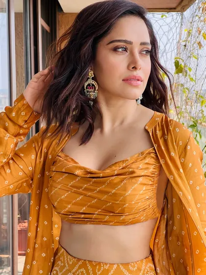 A vibrant bandhani print co-ord set for Nushrratt Bharuccha. This look, featuring a draped top and matching pants with a jacket, is perfect for a festive brunch or a casual wedding event.