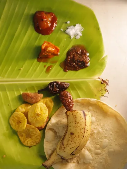 The experience begins with these small but mighty accompaniments. Tangy pickles, sweet and spicy chutneys, crunchy banana chips, and a crispy pappadam awaken the palate for the feast to come.