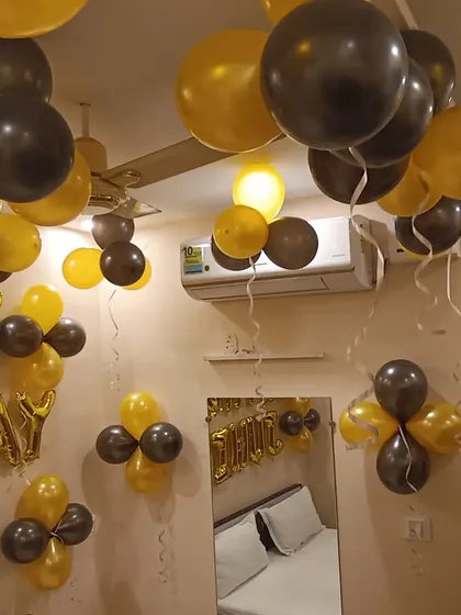 A close-up of the gold and black balloons floating on the ceiling. This simple technique is very effective for creating a festive atmosphere in any room.