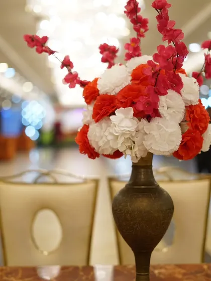 A close-up of a floral centerpiece on a guest table. The shallow depth of field creates a beautiful, soft background.