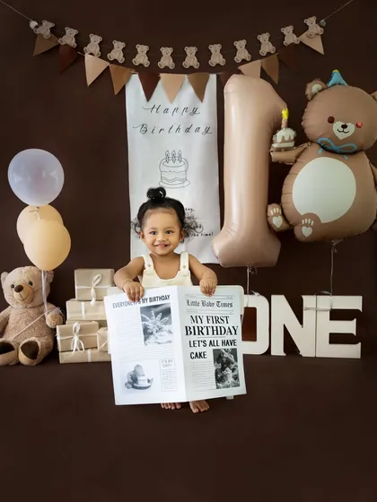 Another fun shot with the birthday newspaper prop, this time with the baby peeking over the top with a big smile.