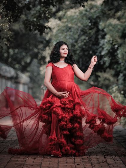 This solo shot showcases the incredible volume and movement of the red ruffled gown, making the mom-to-be look and feel like a queen.