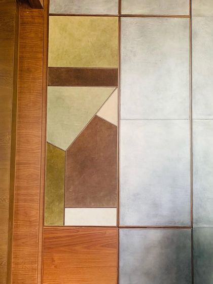 A wall panel detail combining wood with custom-colored leather in a geometric pattern. This kind of material play is central to our work, creating unique and tactile surfaces.