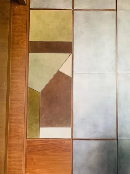A detail of a custom wall unit, where panels of leather in earthy tones are combined with wood and metal. This exploration of materiality creates a distilled sensory richness and a quiet, tactile presence in this contemporary home.