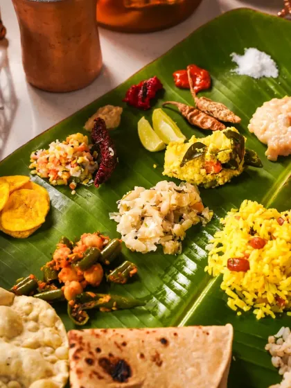 A close-up view of the various side dishes (thoran, pachadi, avial) served on a banana leaf during Onam. The vibrant colors and fresh ingredients are the heroes of this shot.