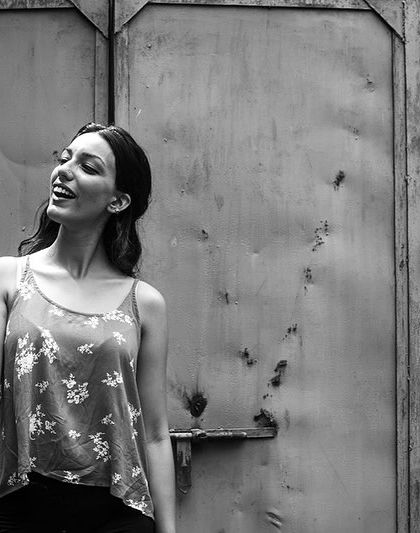 A woman with a fan against a rustic, textured background. This black and white portrait has a timeless, classic feel.