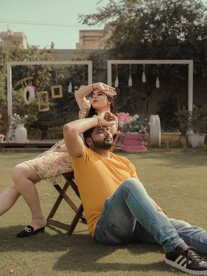 A fun and unconventional pose from a garden pre-wedding shoot, showcasing the couple's playful personality.