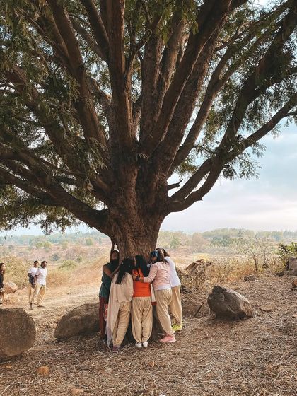 Students embrace a large, ancient tree, feeling its grounding energy. Connecting with nature is a core part of our practice here, reminding us of our roots and our connection to all living things.