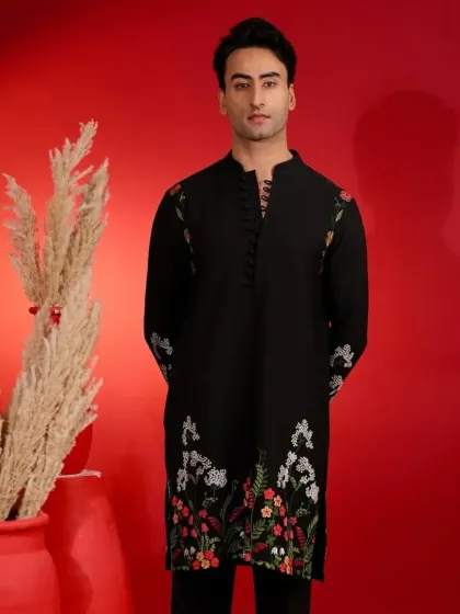 This black kurta features delicate, multi-color floral thread embroidery along the hem and sleeves. It's an artistic and elegant piece for any special occasion.