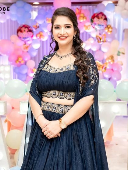 Why own when you can rent the spotlight? This client looks stunning in a navy blue gown with an embellished bodice and cape sleeves.