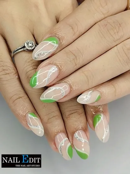 A fresh and modern design with abstract green shapes and swirling silver glitter lines on a sheer nude base. This look is both artistic and elegant.