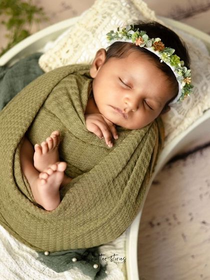 A different angle of the green waffle wrap session, with the baby resting in a white moon-shaped prop.