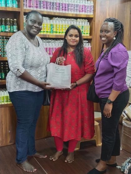 We are proud that our products, made in India, are loved worldwide. Here, our founder poses with happy international customers at our store, holding a bag of our natural products.
